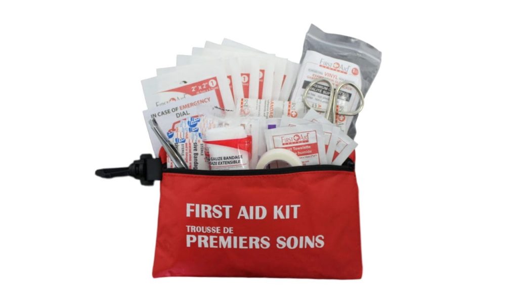 Close-up of essential first aid kit items, such as adhesive bandages, tweezers, and a other