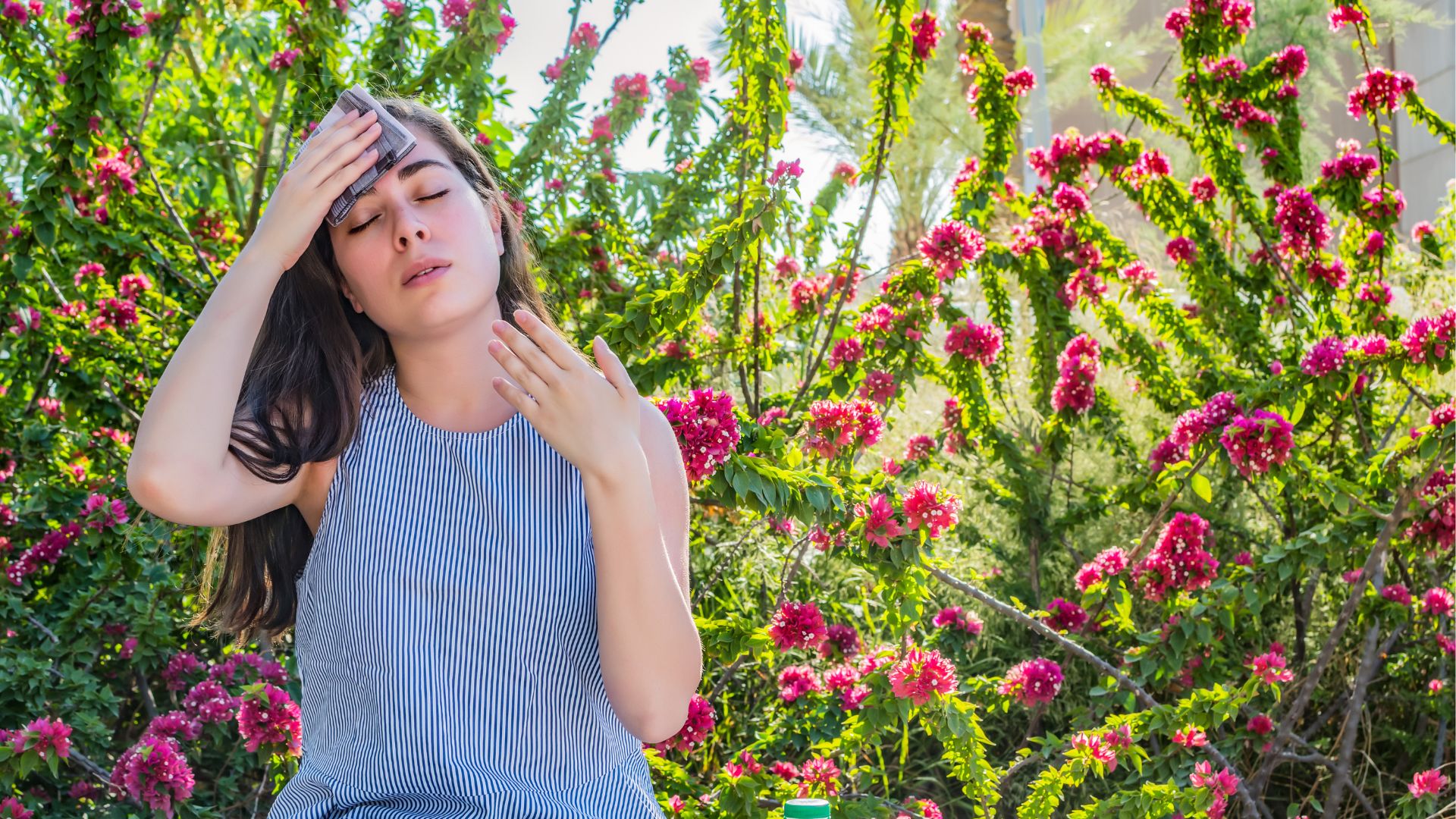 A woman sweating from the intense heat, trying to stay cool in hot weather 