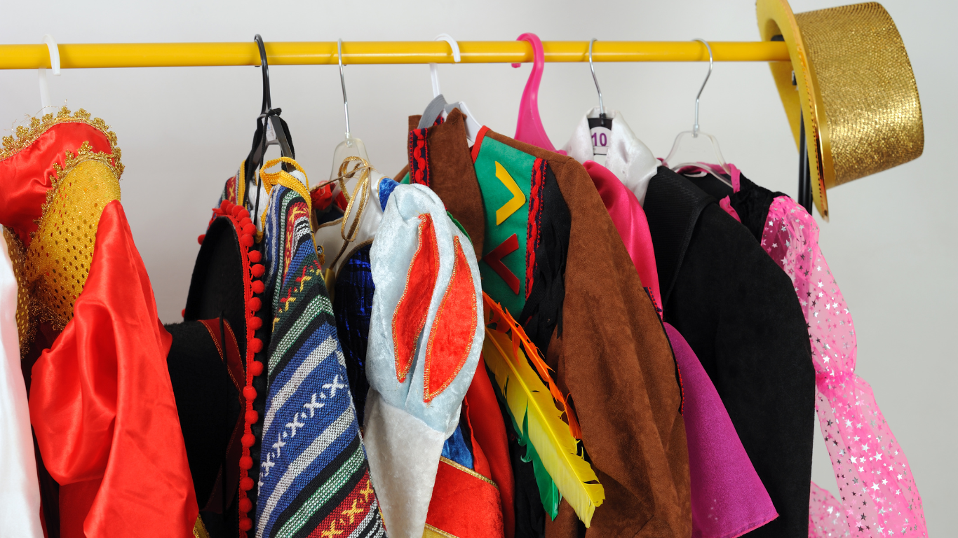 Different Halloween costumes hanging on a clothing rack.