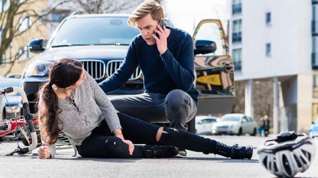 A person assisting a woman in a car crash