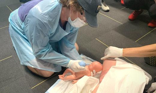 advanced cpr student practicing how to deliver a baby at the waterloo location