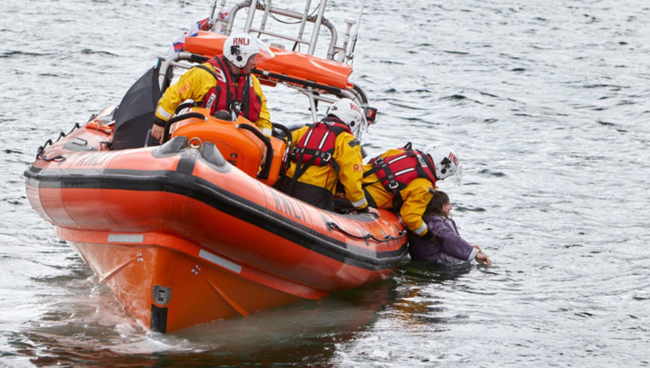 A group of people saving someone's life during boating showcasing how important is first aid for boaters.