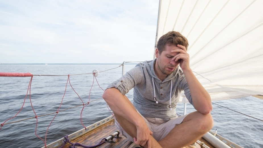 A person experiencing motion sickness during boating.