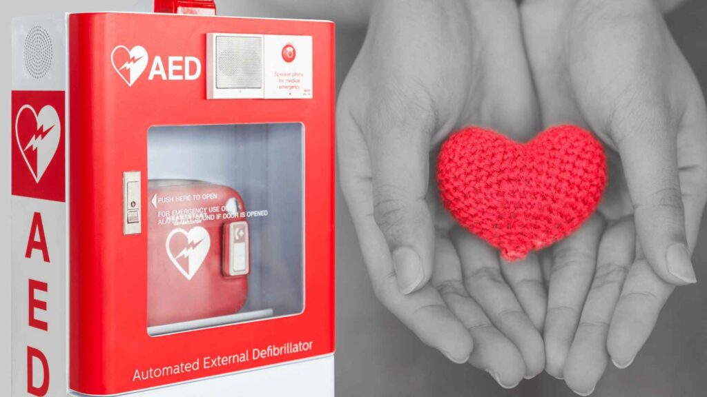 AED machine with some hands showing a heart