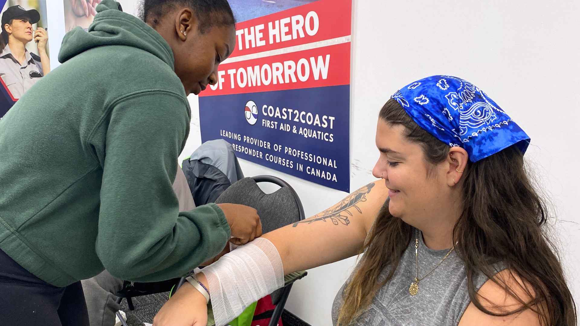 Two ladies practicing bandage techniques in a first aid course