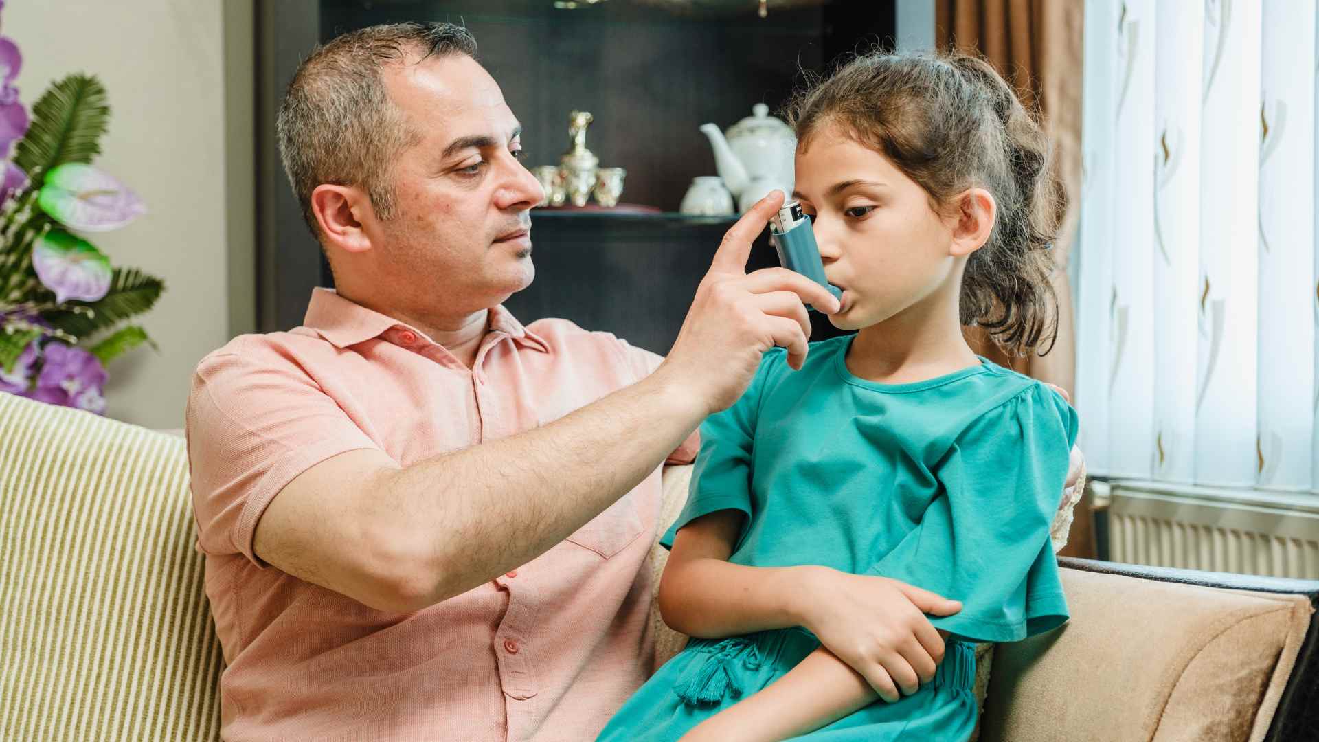 a parent helping his child with breathing problems.