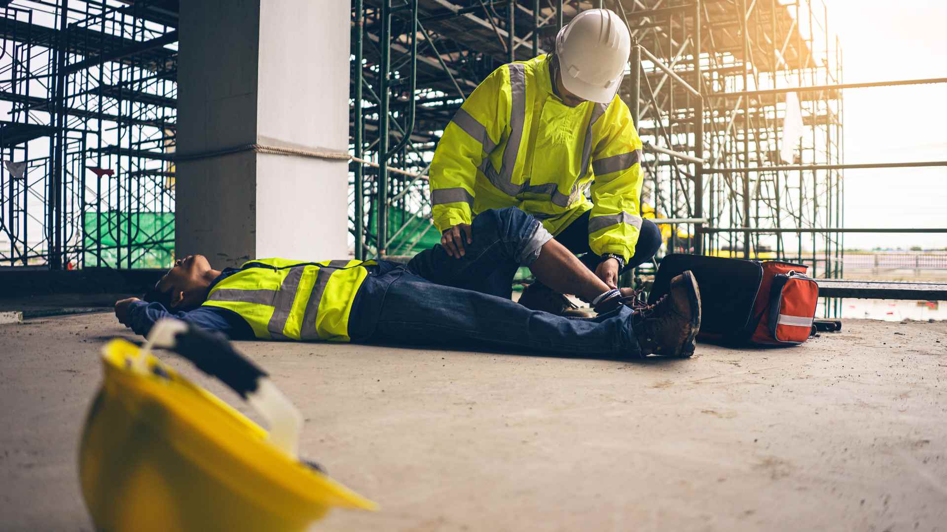 A worker tarined in workplace first aid training helping his co-worker.