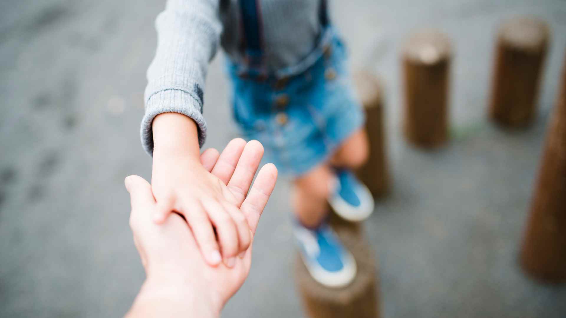 A person holding hand of his son.