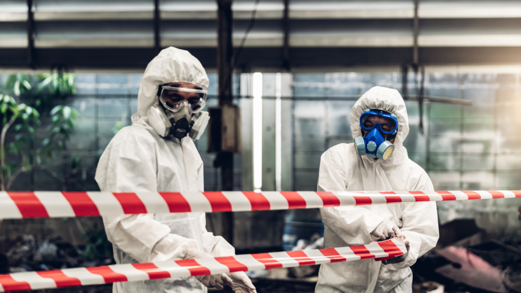 Emergency responders in protective gear marking a chemical hazard zone