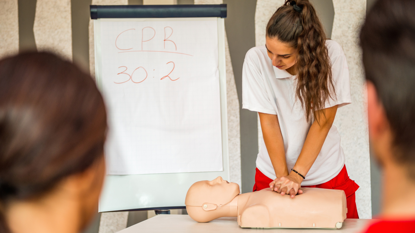 A lady performing CPR training on a mannequin