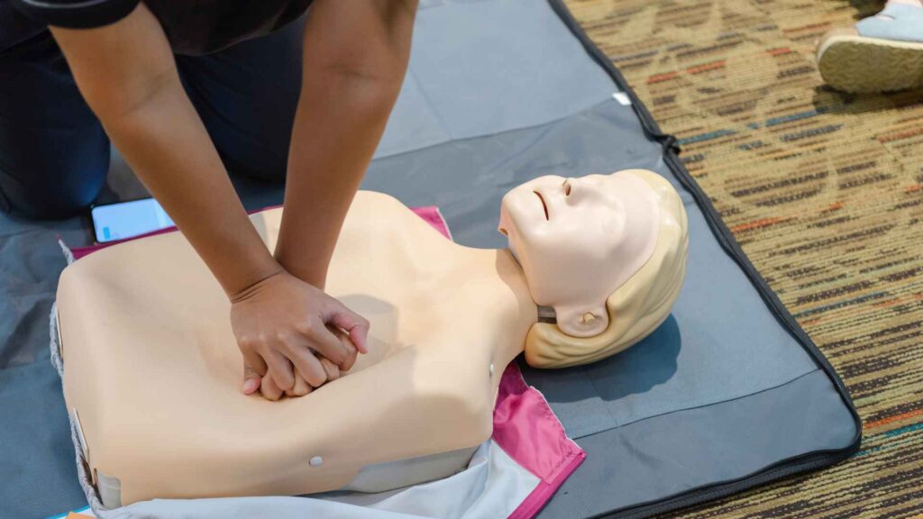 A student performing CPR in a first aid course at Coast2Coast