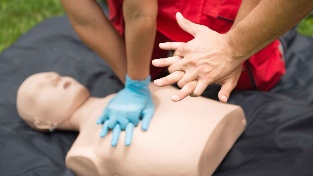 A first aid instructor showing how to place hand for CPR training