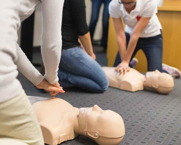 Instructors showing how CPR compressions are made