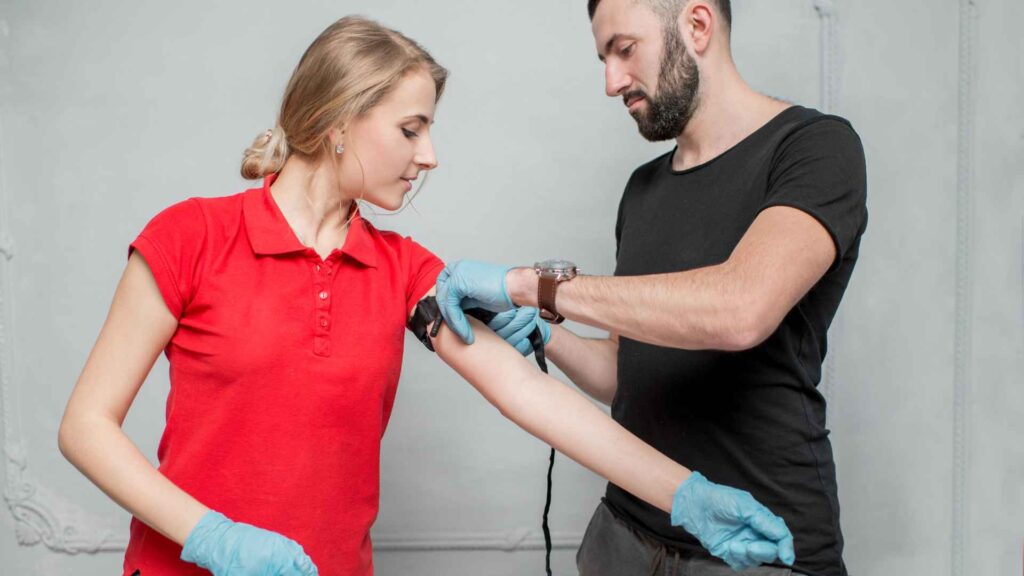 a student applying a tourniquet in a first aid course