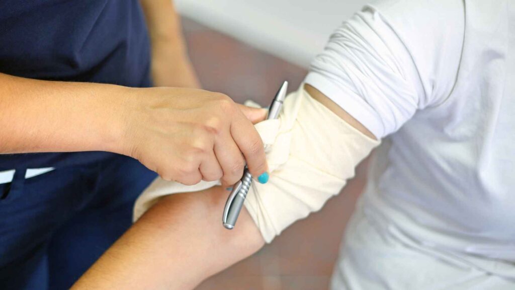 a first aider using an improvised tourniquet